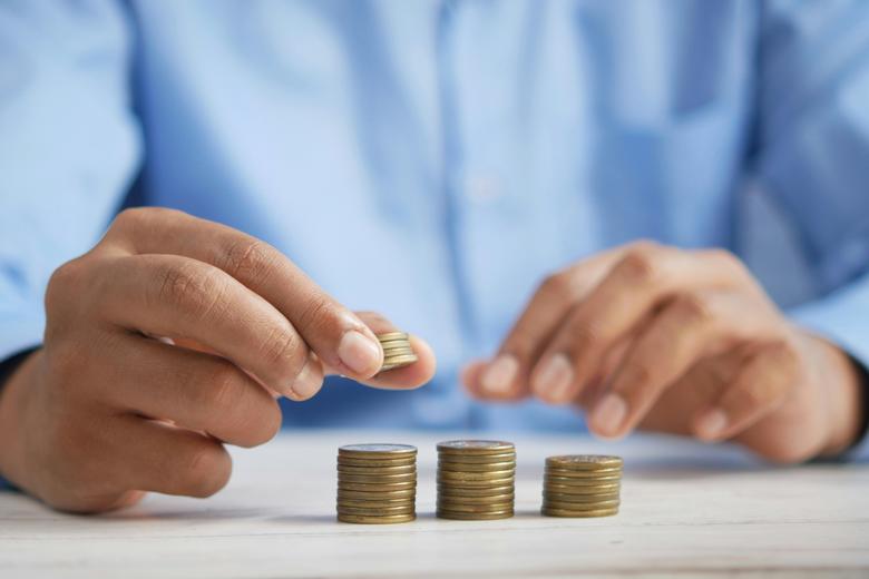Close up of hands putting together stacks of coins