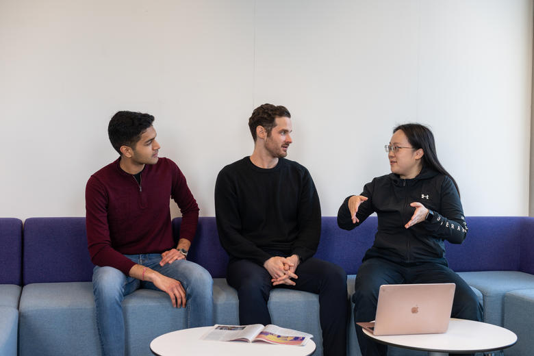 Three members of the Department sitting on a sofa talking