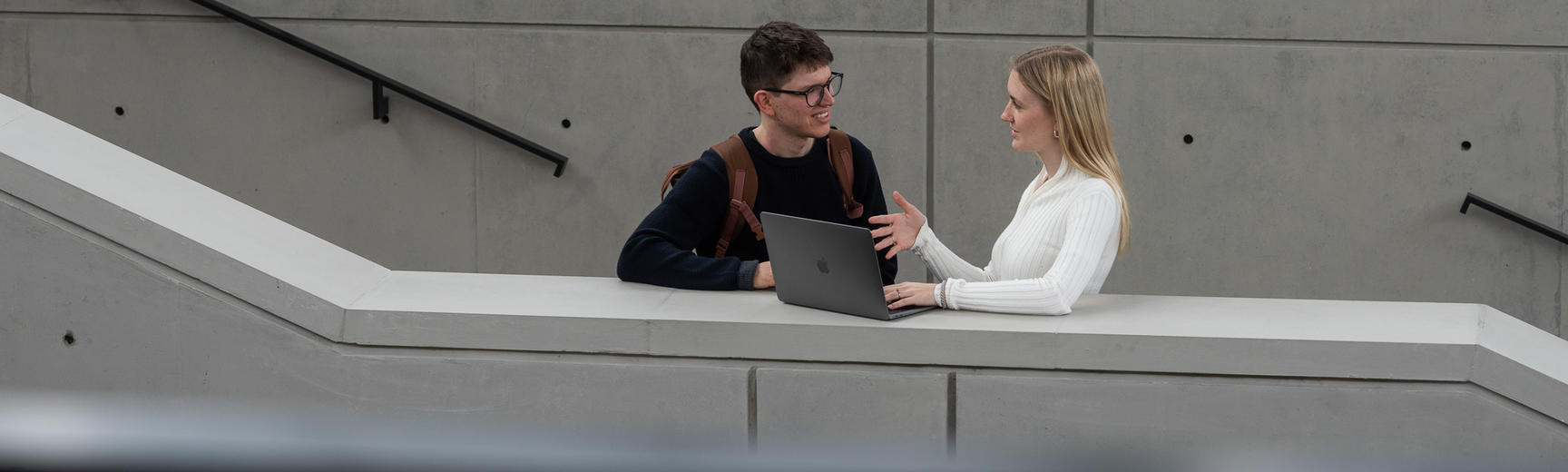 two students look at laptop