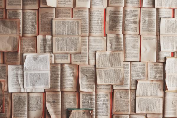 Piles of open books cover the floor