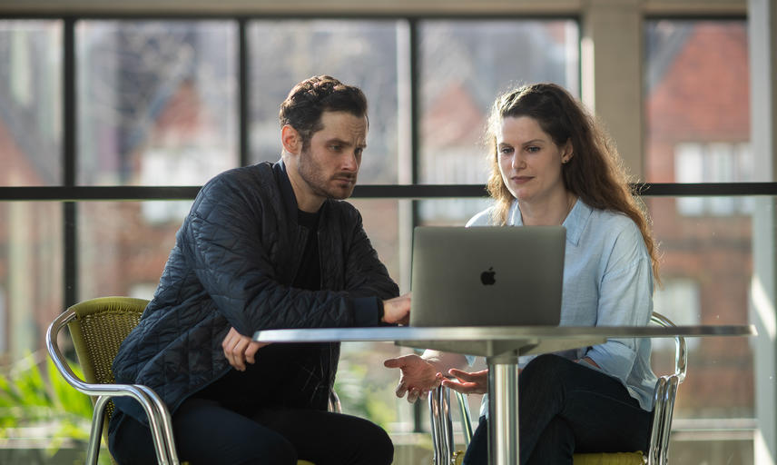 Two academics looking at a laptop