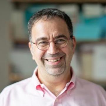 Headshot of Daron Acemoglu smiling